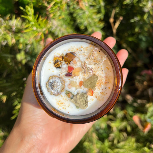 Eucalyptus soy candle in a glass jar topped with dried botanicals